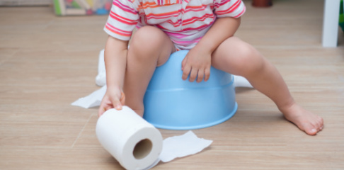 Child on potty with toilet paper