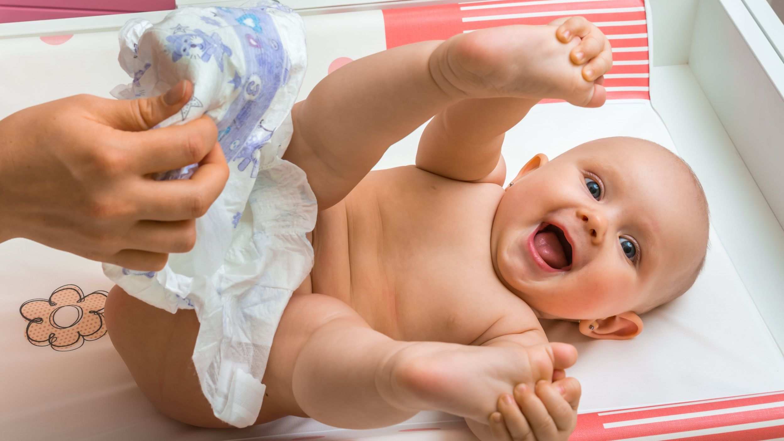 Mom changing a smiling baby girl's nappy