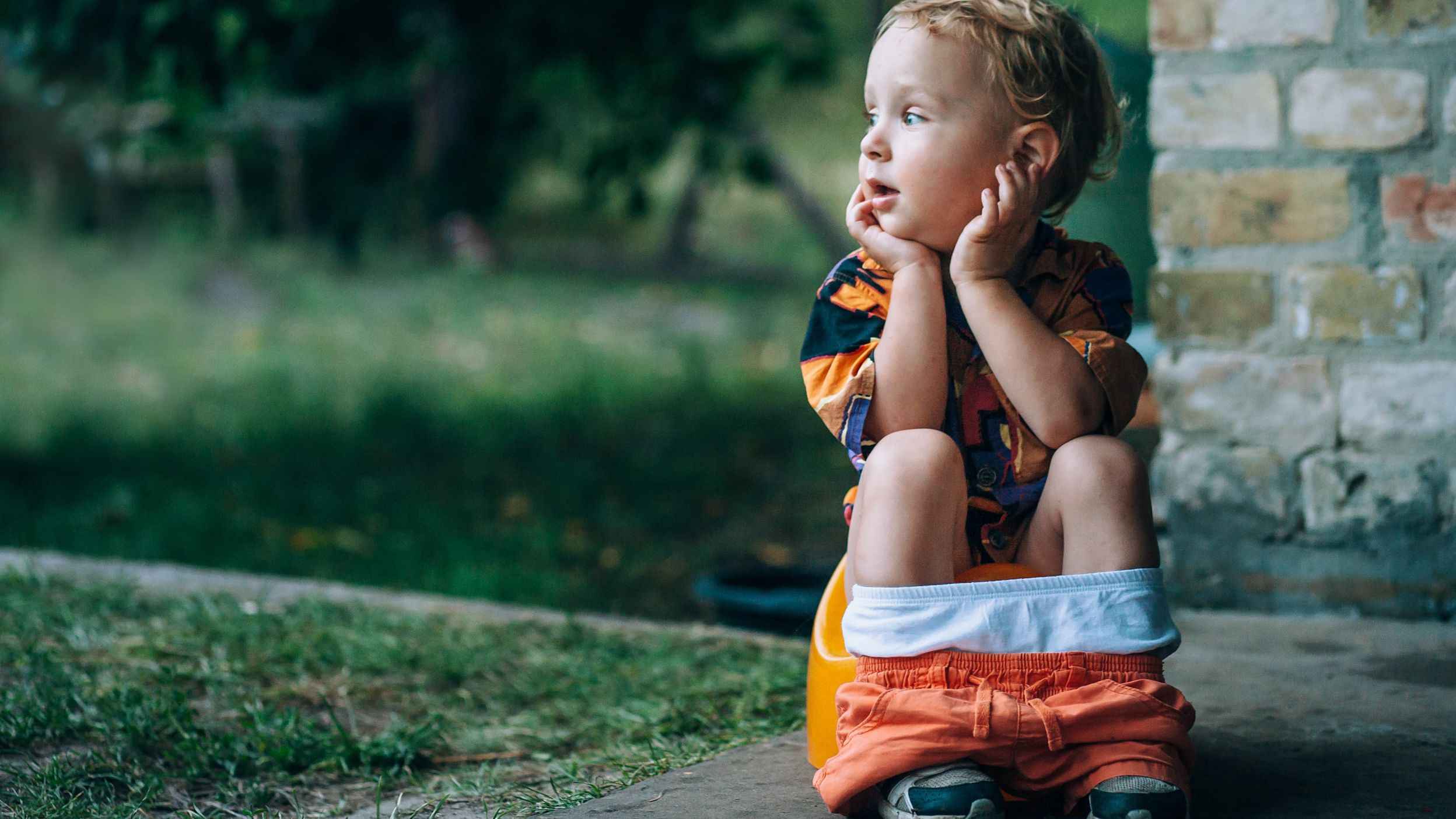 Toddler sitting on a potty outdoors