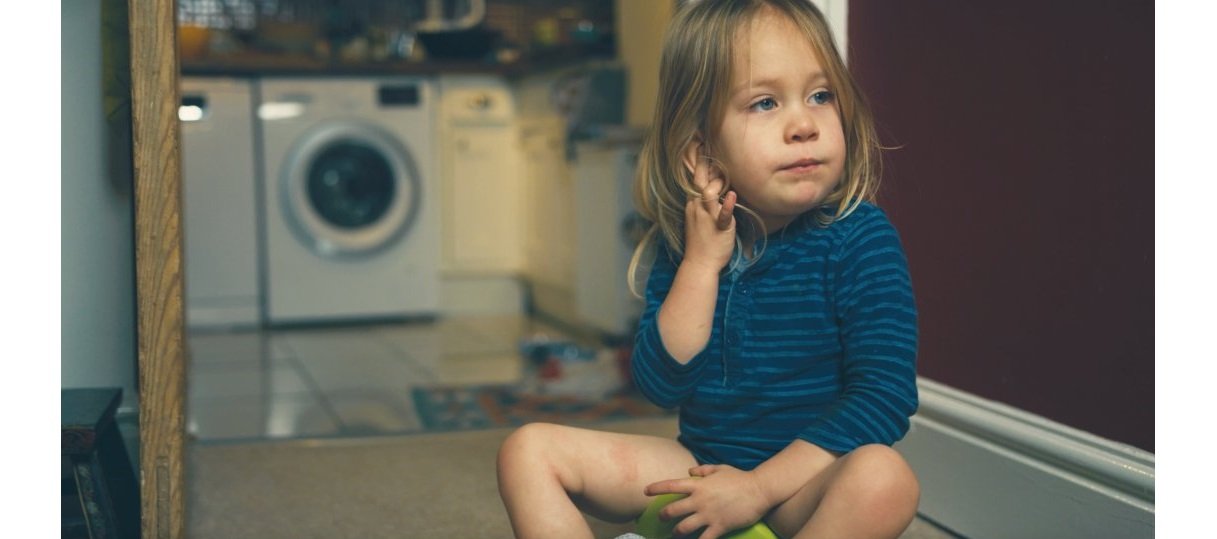 Toddler sitting patiently on a potty