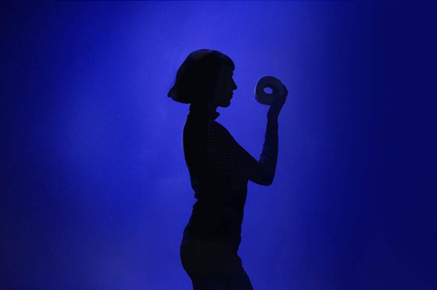 A sillouette of a woman looking at a toilet roll