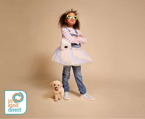 A girl wearing sunglasses standing by a labrador puppy